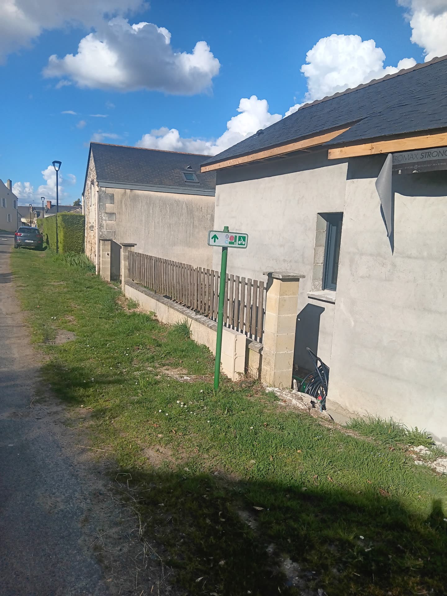 Débord de toit en bois et couverture ardoise sur un bâtiment en Anjou