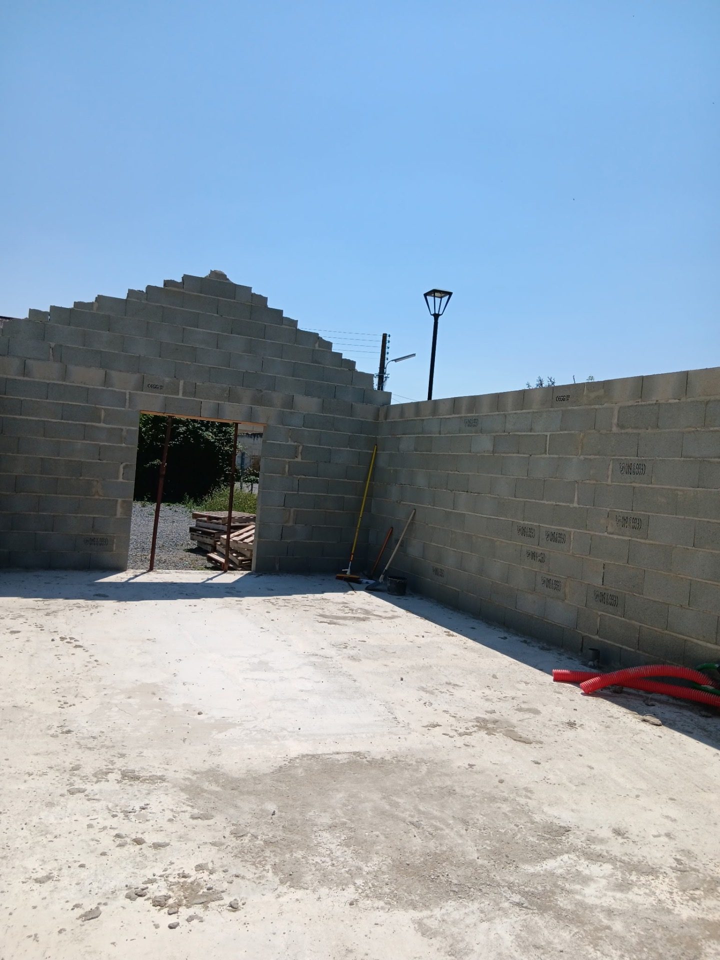 Murs en parpaings et pignon montés pour un garage en construction dans le Maine-et-Loire